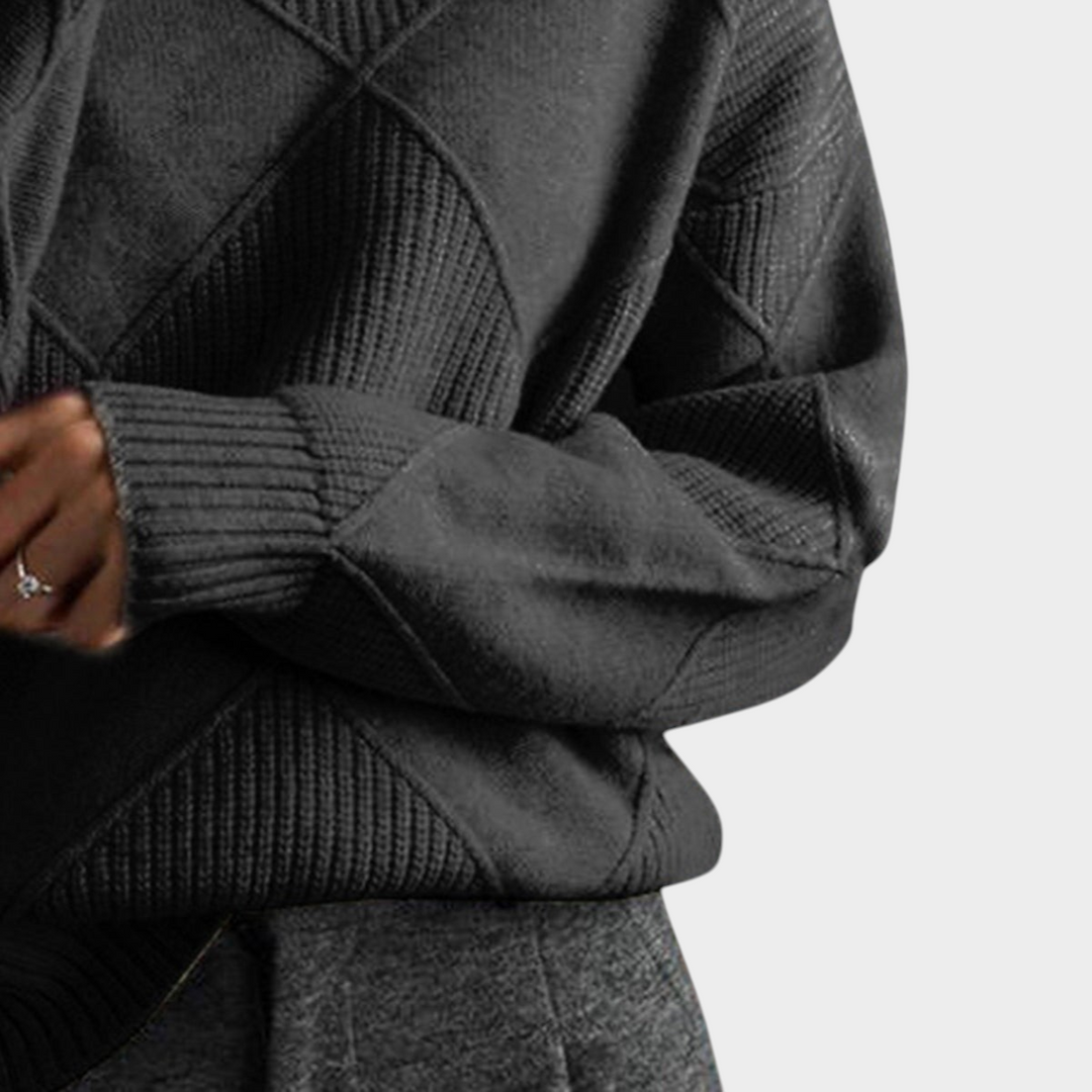 Zane & Inese Gaida dark grey knit sweater with a high collar and geometric diamond pattern texture