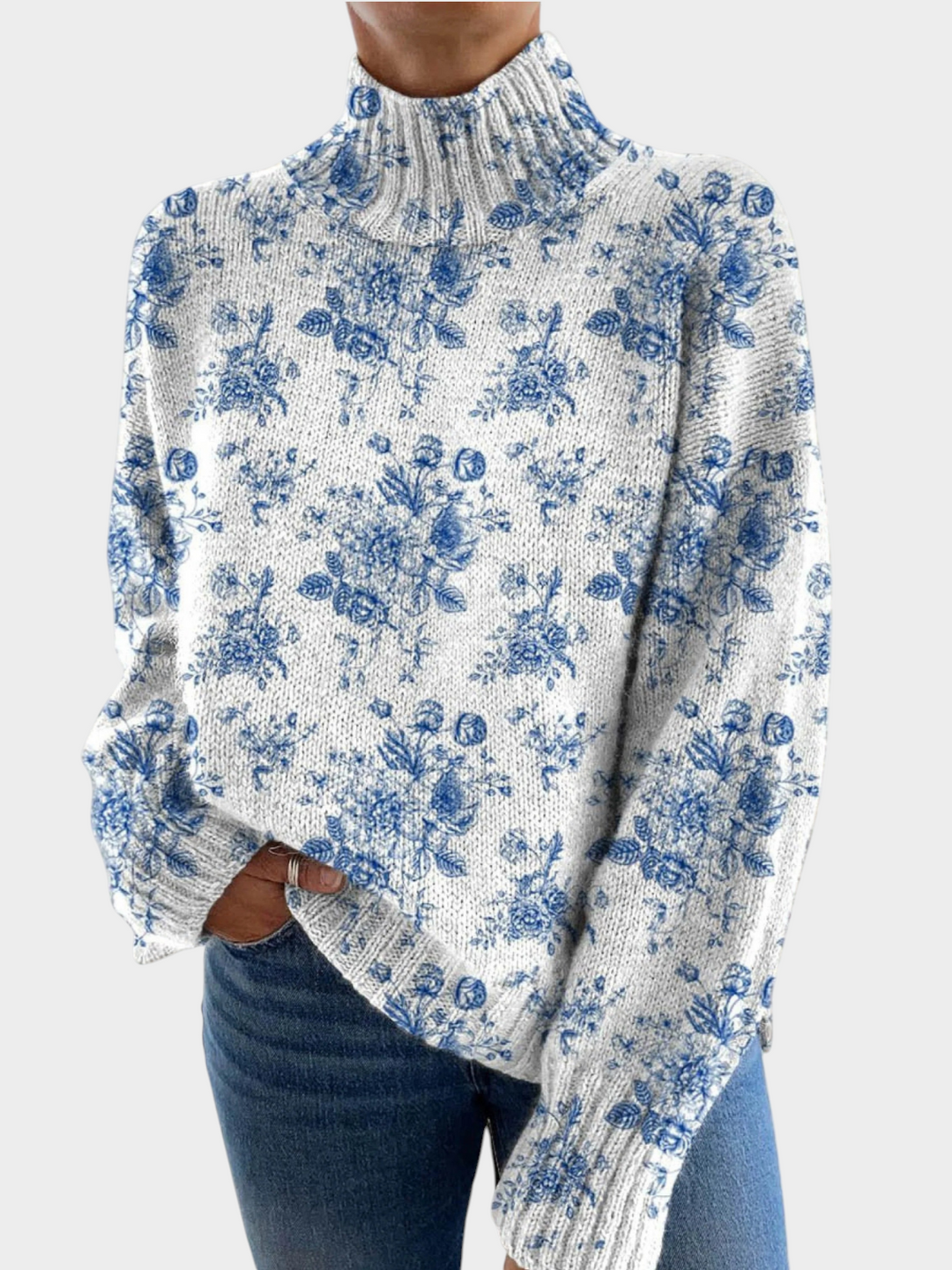 Zane & Inese white knit sweater with blue floral pattern, high ribbed turtleneck, and relaxed fit.