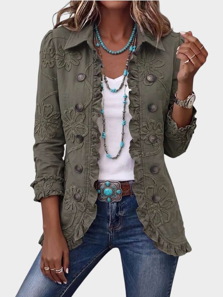 Zane & Inese olive green boho jacket with floral embroidery, ruffled trim, and pointed collar worn over a white top